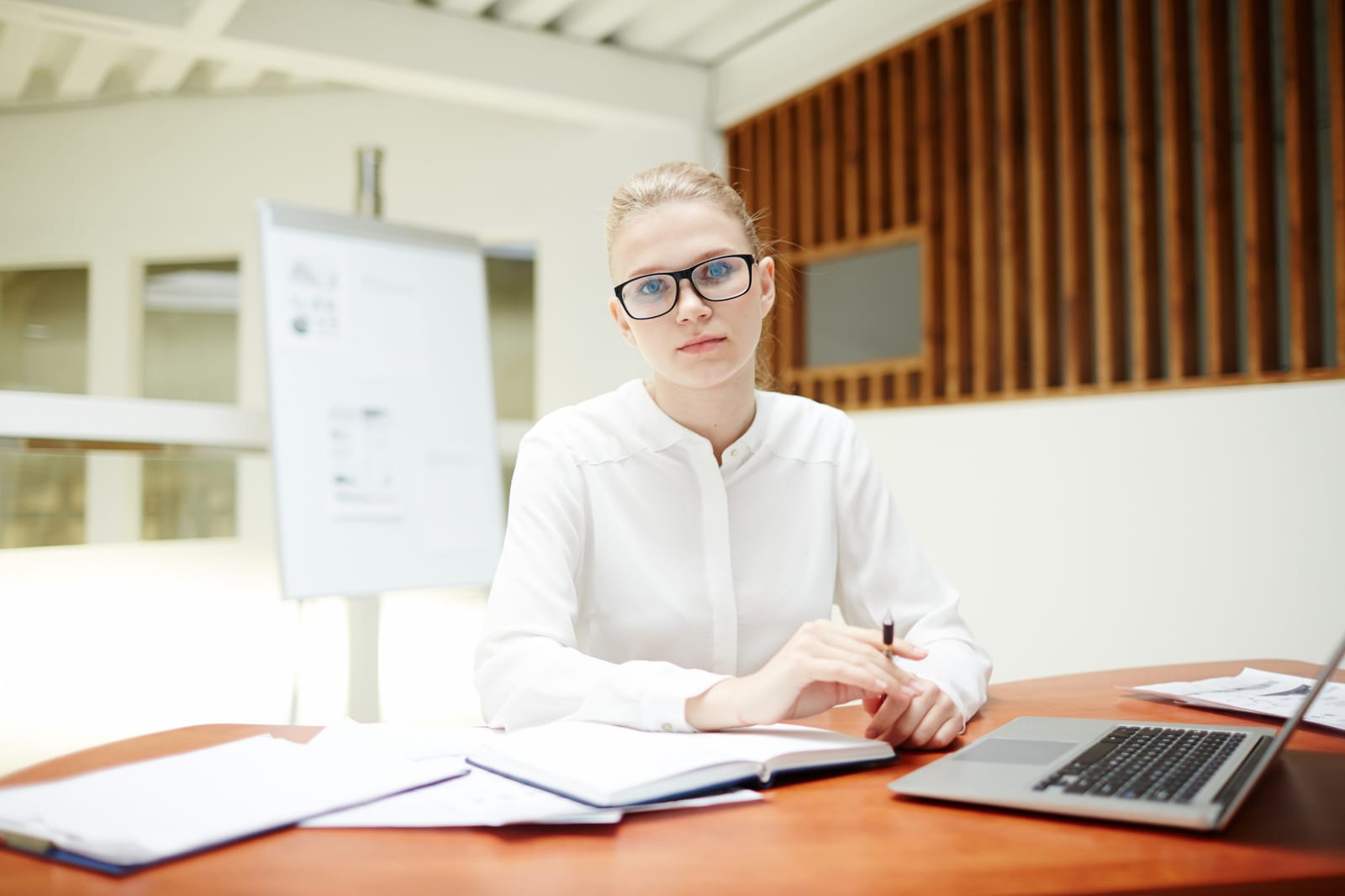 Formatrice finanziaria al lavoro con documenti e calcolatrice su una scrivania